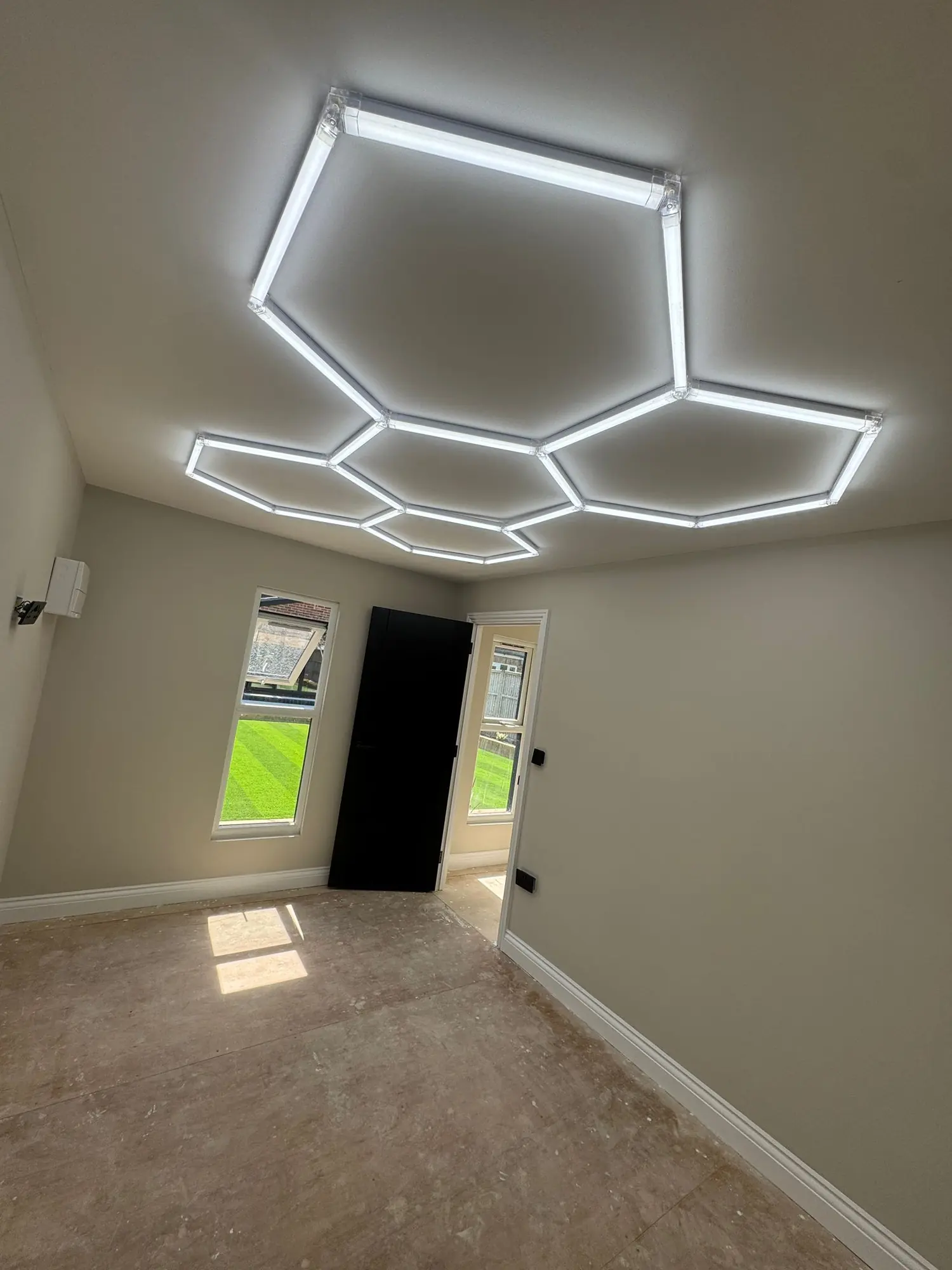 Hexagonal LED grid lighting installed in a garage workshop